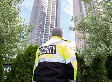 A security guard in uniform patrolling a residential area.