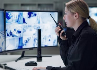 Watch, security and woman with radio, cctv and monitor for danger, talking and control room for gua.